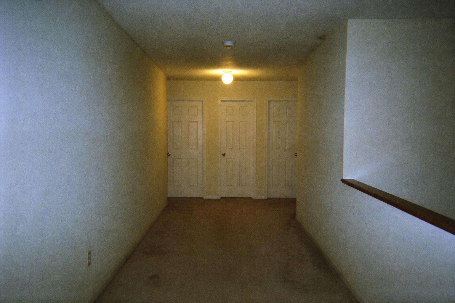 THE UPSTAIRS HALLWAY — One door is open.